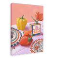 The "Hôtel Dodo Paprika Puszta Giclée Canvas Print" from Hôtel Dodo showcases a framed painting that depicts a yellow bell pepper, red pepper, a paprika box labeled "Hungarian paprika," and a red tulip on a table set with decorative plates and a pink-checkered cloth.