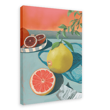 The Mellow Pomelo Giclée Canvas Print by Hôtel Dodo portrays a still-life scene with a sliced grapefruit, a whole grapefruit, and a blood orange on a blue table. Some leaves and a piece of paper are also included, set against an orange gradient background.