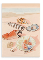 A beach scene featuring various seashells, a piece of coral, and a striped feather arranged on the sand, showcasing the Tiny Treasures Giclée Canvas Print by Hôtel Dodo. The ocean is visible in the background, evoking calm moments by the sea.
