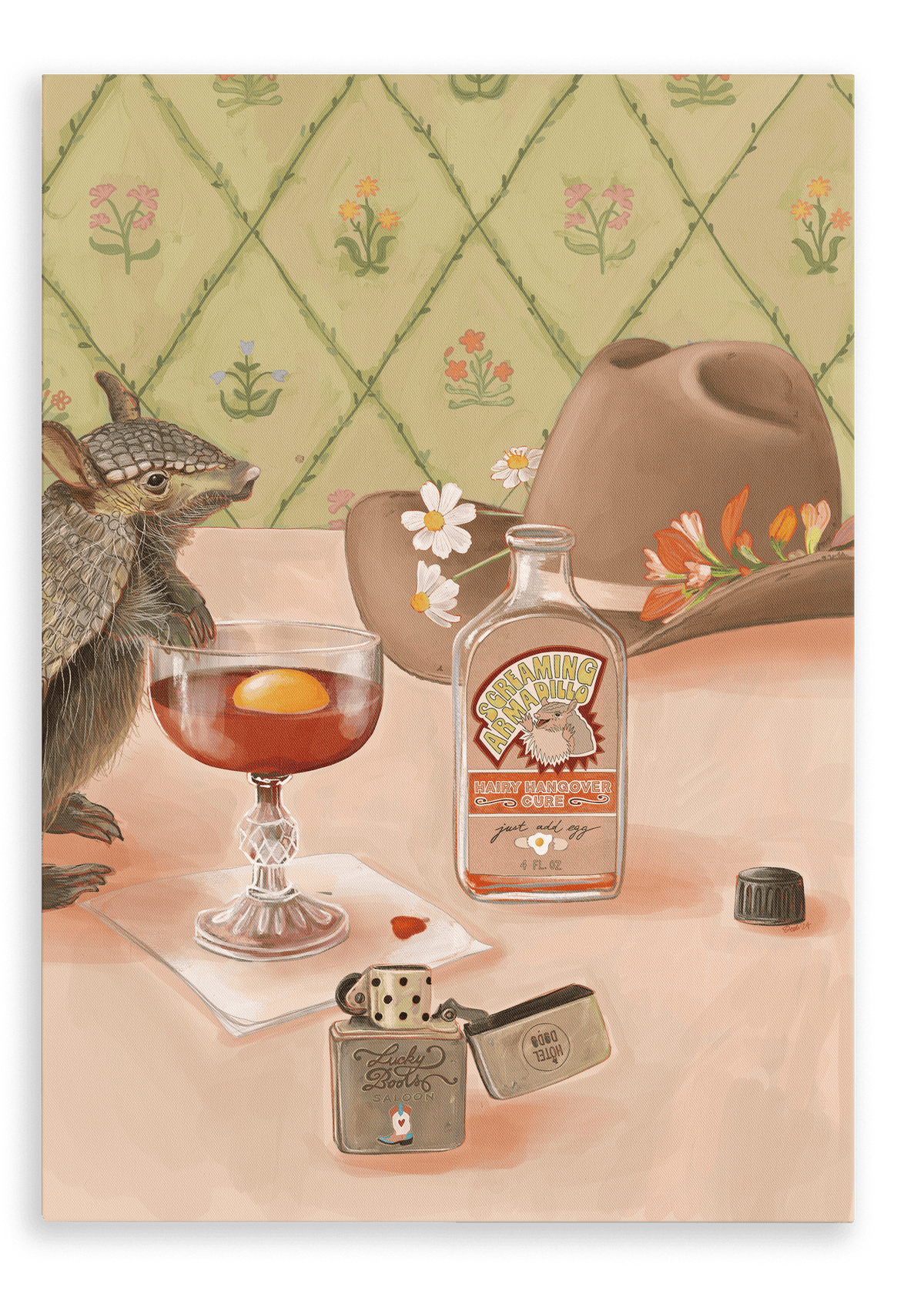 A small armadillo stands beside a glass of the Prairie Oyster from Hôtel Dodo, with a whiskey bottle, lighter, and cowboy hat arranged on a pink table against floral wallpaper; this scene is captured in the Prairie Oyster Giclée Canvas Print.