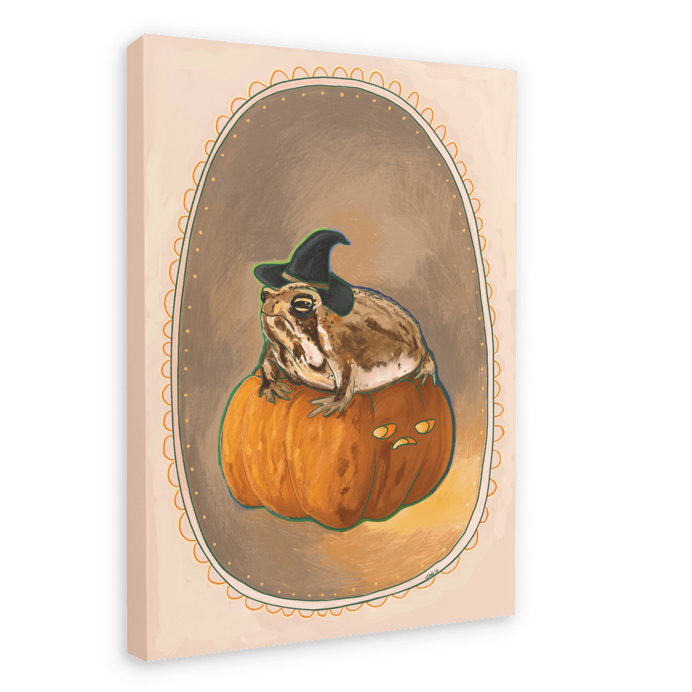 The Grumpy Spiced Pumpkin Giclée Canvas Print by Kitsch Kanaveral features an illustration of a witchy rain frog wearing a witch hat, sitting on a carved pumpkin with a grumpy face. The image captures autumn vibes and is set within an ornate oval frame.