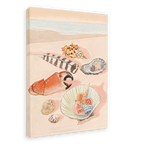 A beach scene featuring various seashells, a piece of coral, and a striped feather arranged on the sand, showcasing the Tiny Treasures Giclée Canvas Print by Hôtel Dodo. The ocean is visible in the background, evoking calm moments by the sea.