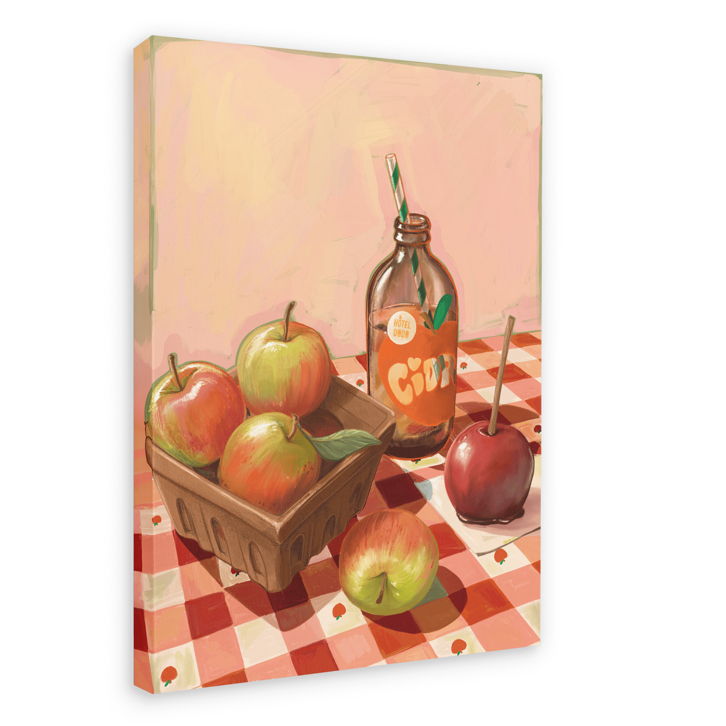 Hôtel Dodo’s “Apple Core Giclée Canvas Print” features a charming scene of apples in a carton, a glass bottle of fresh cider with a straw, a toffee candy apple, and a loose apple, all arranged on a red-checkered tablecloth set against a light pink background.