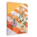 A L’Orange Giclée Canvas Print by Hôtel Dodo depicts two cocktails with orange slices and straws on a striped table, complemented by curated table settings and a small vase of white flowers marked with the brand’s name.