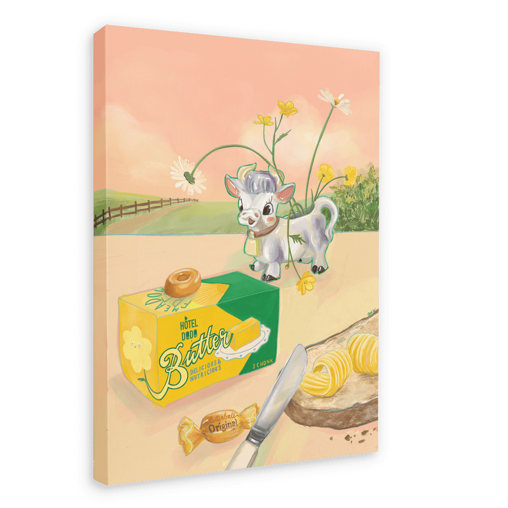 Bring a whimsical touch to your space with the “Butterlicious Giclée Canvas Print” by Hôtel Dodo, featuring a charming cow in a chef hat standing behind a butter box decorated with vintage butter curls and topped with caramel, surrounded by sliced bread, a knife, delicate flowers, and set against a picturesque country landscape.