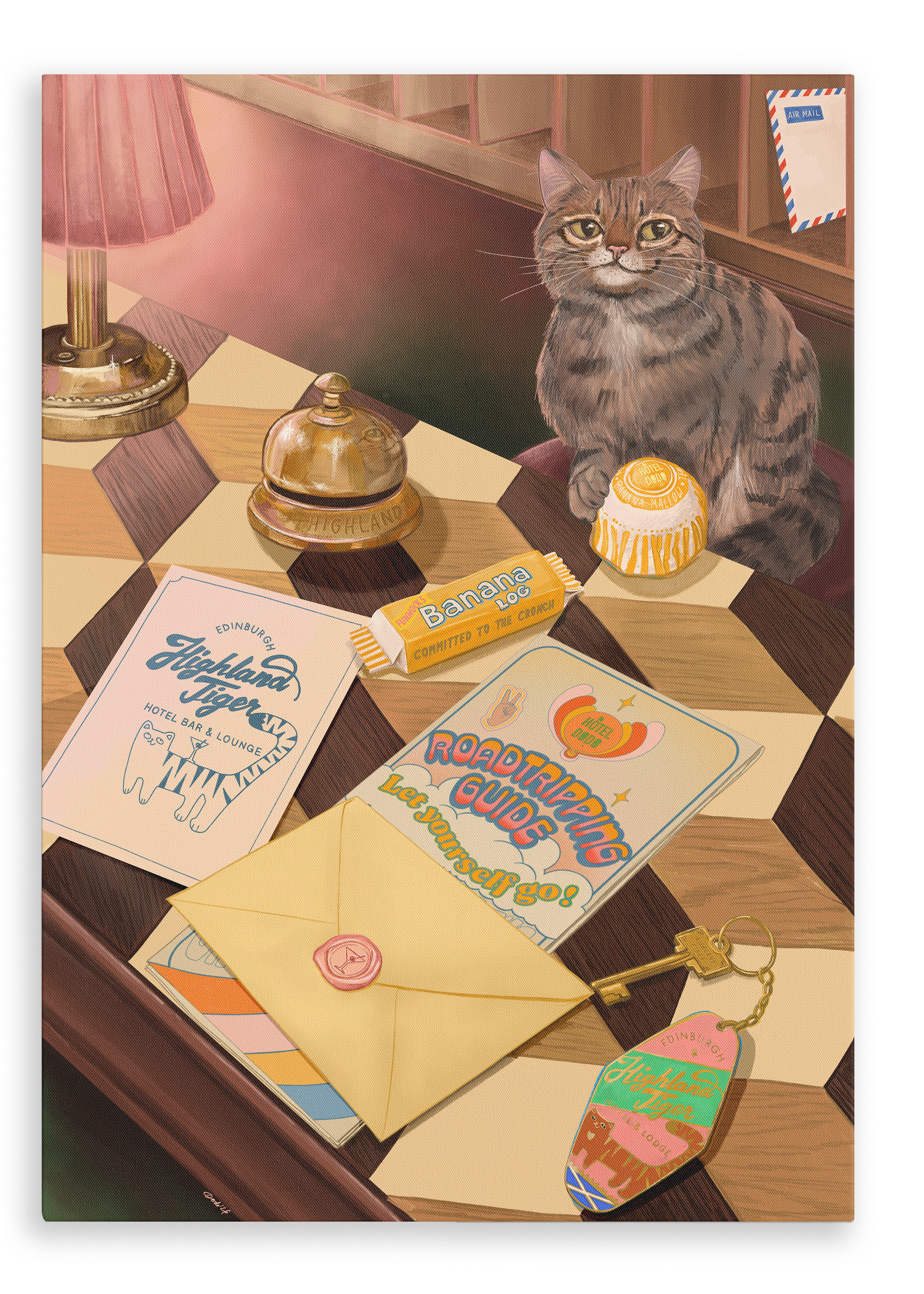 A tabby cat sits on a checkered table beside travel items—including postcards, an envelope, a banana candy, a bell, a keychain, and a round yellow candy—while the Highland Tiger Lodge Giclée Canvas Print by Hôtel Dodo is displayed nearby.