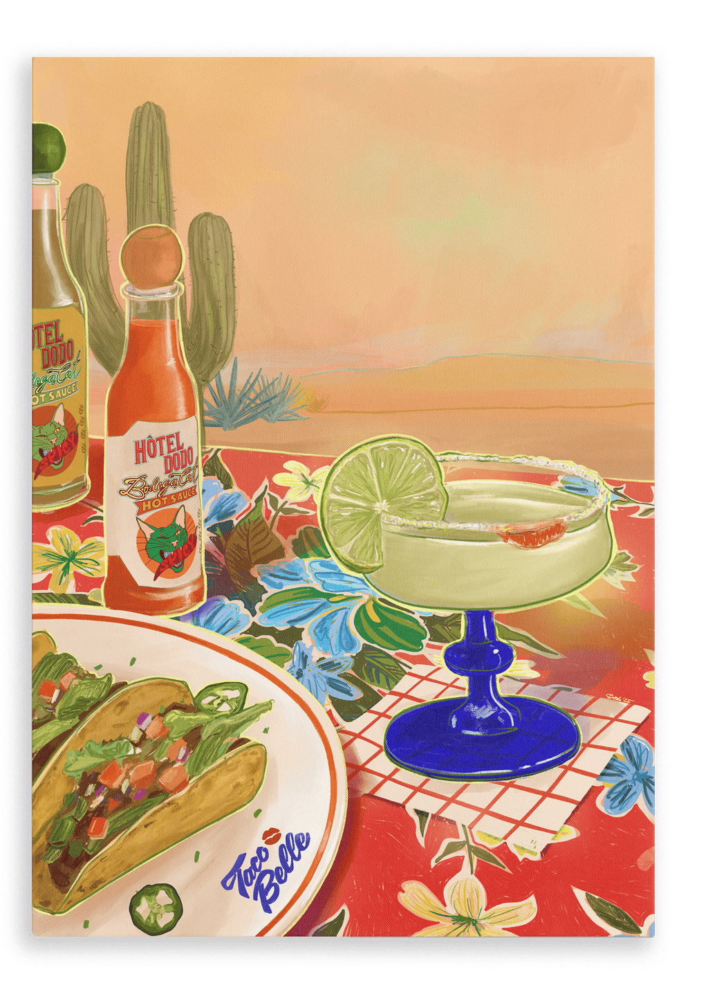 A zesty margarita with a lime slice, crunchy tacos on a plate, and bottles of Bodega Cat Hot Sauce are beautifully arranged on a floral tablecloth adorned with cacti and a vibrant desert landscape in the background, as depicted in the “Taco Belle Giclée Canvas Print” by Hôtel Dodo.