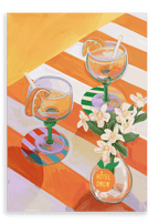Two orange sodas—garnished with fresh slices and straws—rest on a striped table curated with elegant place settings, accompanied by a small white vase labeled “Hôtel Dodo,” beneath the vibrant A L’Orange Giclée Canvas Print from Hôtel Dodo.