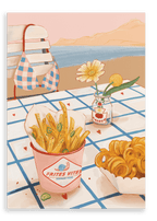 A giclée canvas print by Hôtel Dodo titled “Frites Vites,” featuring a table by the beach with a chair, a bikini top, gourmet fries topped with sliced jalapeños, curly fries, and a small jar with two flowers, all set against a stunning sea view.