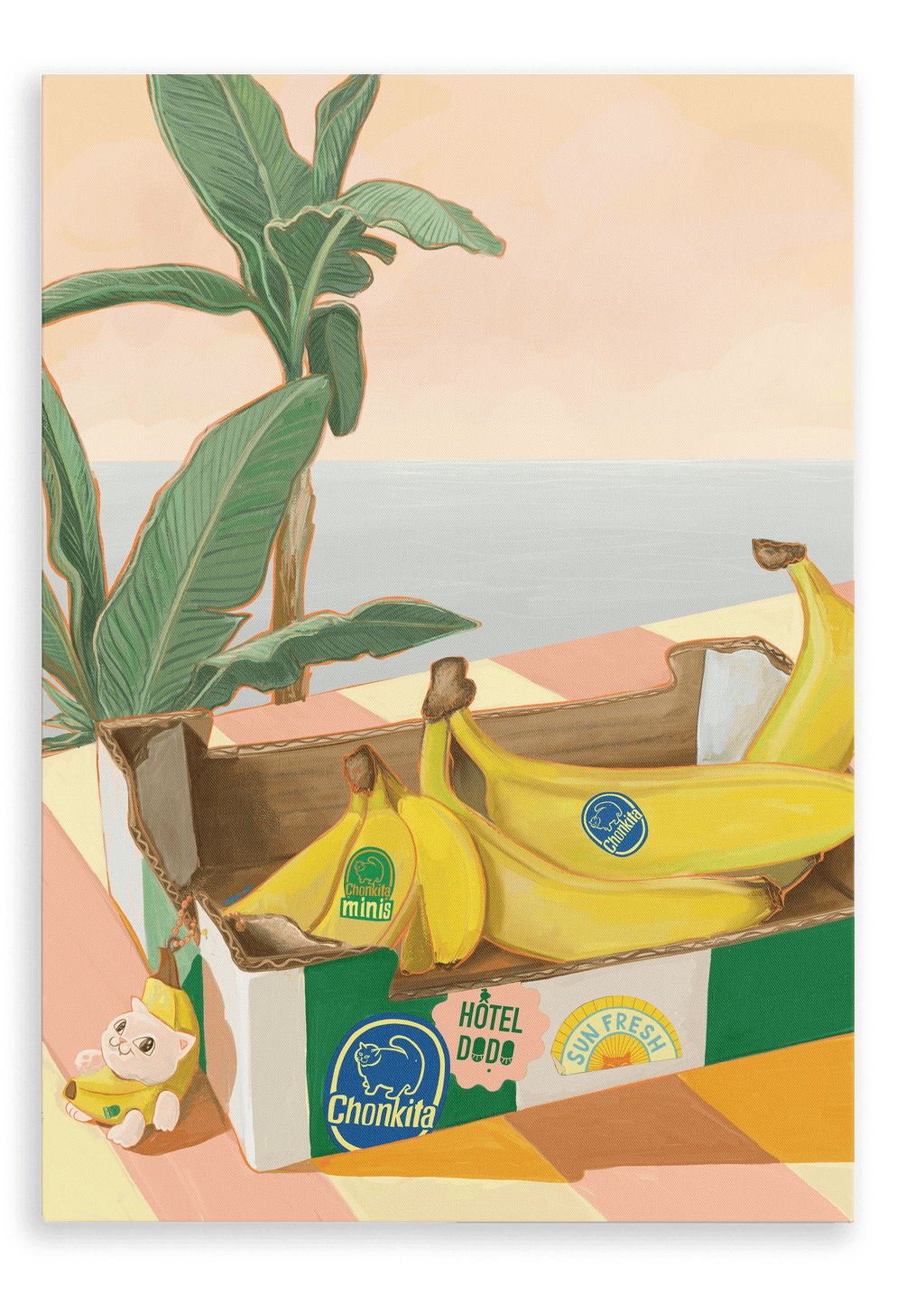 A Chonkita Bananas Giclée Canvas Print by Hôtel Dodo—featuring a lovable banana cat cozily nestled in its peel—rests on a checkered table beside a plant, with an assortment of bananas adorned with colorful stickers and a small figurine lounging nearby.