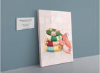 A Hôtel Dodo “Platypus Pool Pals Giclée Canvas Print,” featuring three colorful inflatable pool rings and a plush platypus, leans against a tiled wall beside a placard with artwork details.