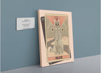 A framed Death Canvas Print from Tarot Cats, inspired by vintage tarot card illustrations and depicting a skeletal cat and skull, is displayed on a stand beside a wall plaque with exhibit details—an intriguing addition to any Tarot Cats collection.