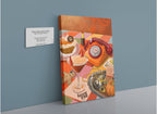 The Harvest Club Giclée Canvas Print by Hôtel Dodo features a vibrant tableau of a vintage phone, cocktail, desserts, lipstick, pumpkin, and gingerbread man arranged on a checkered table, perfectly capturing the playful spirit of spooky season. Displayed on a blue wall next to its gallery label at Hôtel Dodo, this whimsical artwork radiates an enchanting and subtly paranormal charm.