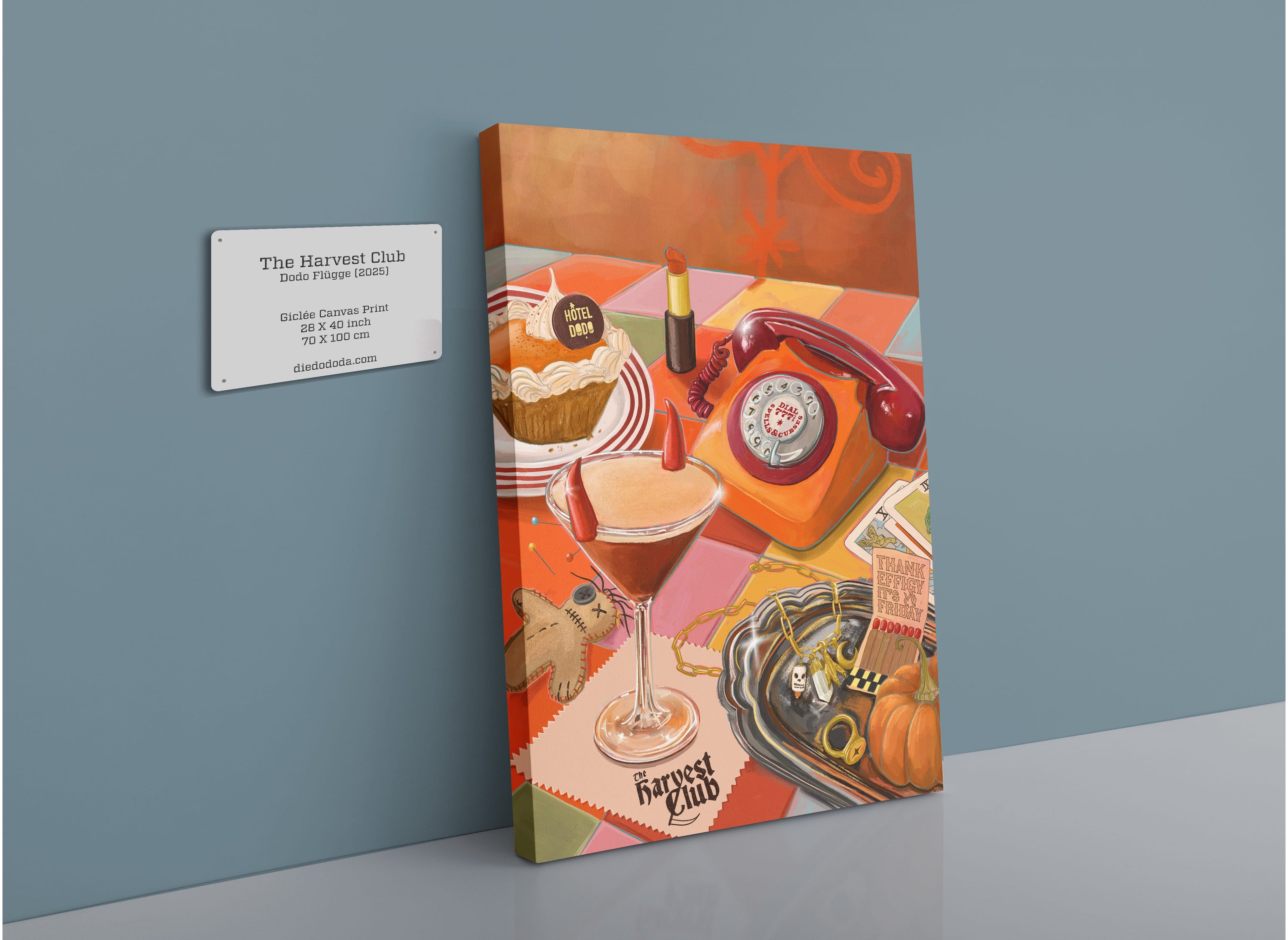 The Harvest Club Giclée Canvas Print by Hôtel Dodo features a vibrant tableau of a vintage phone, cocktail, desserts, lipstick, pumpkin, and gingerbread man arranged on a checkered table, perfectly capturing the playful spirit of spooky season. Displayed on a blue wall next to its gallery label at Hôtel Dodo, this whimsical artwork radiates an enchanting and subtly paranormal charm.