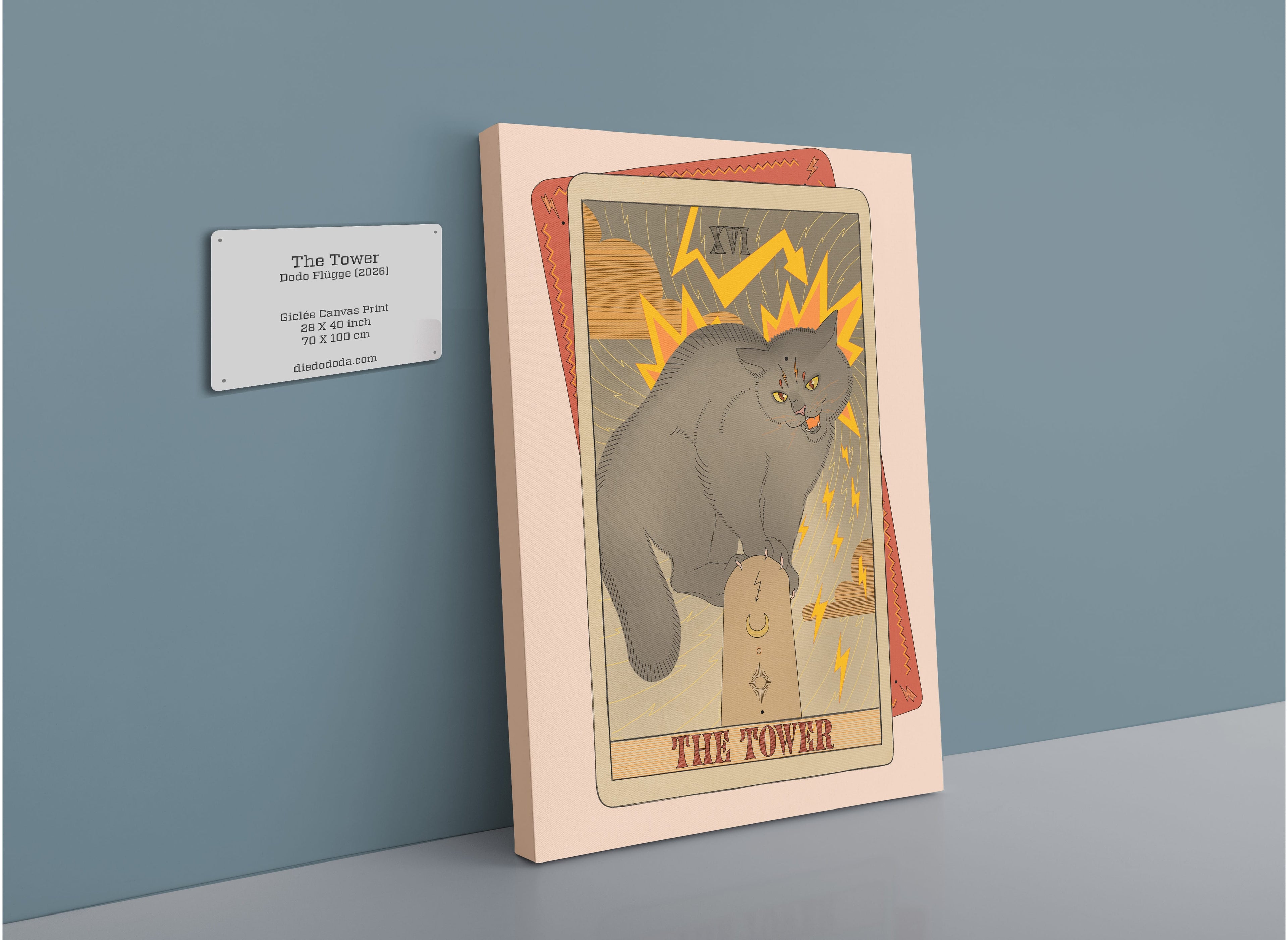 The Tower Canvas Print from the Tarot Cats collection, featuring a gray cat perched on a rock amidst lightning bolts, is displayed with a descriptive plaque on a gallery wall. This framed artwork is ideal for fans of collectible cat art and vintage tarot card designs.