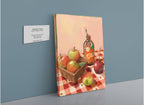 A canvas print by Hôtel Dodo, titled “Apple Core Giclée Canvas Print,” depicts apples, a basket, and a glass bottle resting on a checkered tablecloth—evoking the charm of an apple orchard in autumn. A wall plaque beside it displays the product name and brand.
