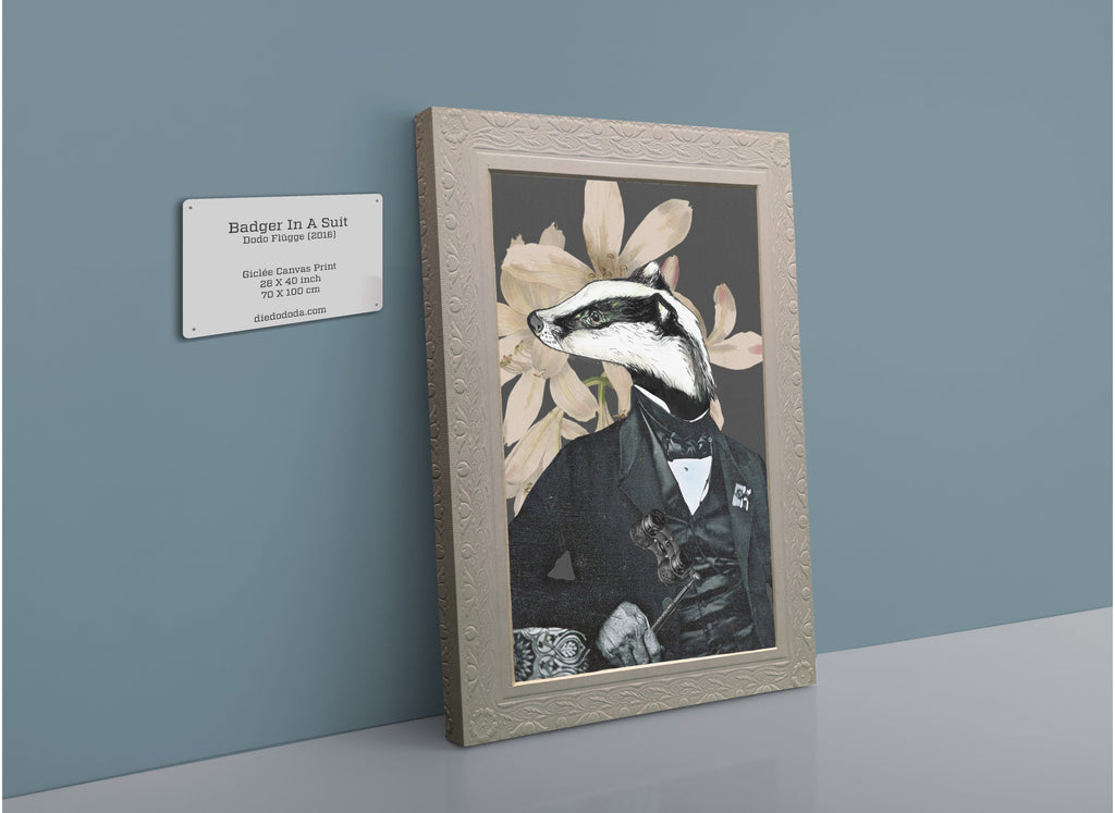 The Badger In A Suit Canvas Print by Animals In Suits features a charmingly illustrated badger dressed in a formal suit, set against a backdrop of vintage botanical flowers. Displayed leaning against a gray wall beside a wall plaque with artwork details, this canvas print combines whimsical animal portraiture with classic botanical art.