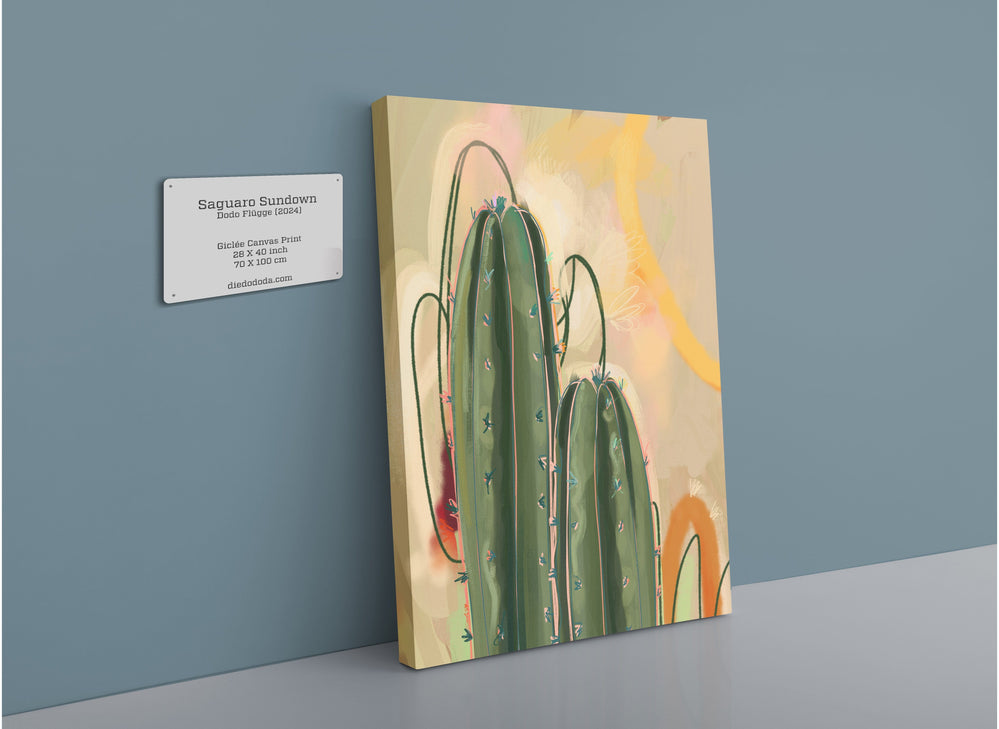 A canvas print titled "Saguaro Sundown Giclée Canvas Print" by Heat Flares hangs on a wall, showcasing tall cacti set against a vibrant, abstract background.