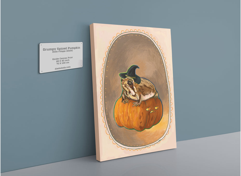 A framed Grumpy Spiced Pumpkin Giclée Canvas Print by Kitsch Kanaveral featuring a grumpy-looking raccoon in a witch hat sitting on a mini pumpkin throne, displayed on a wall with an information plaque beside it.