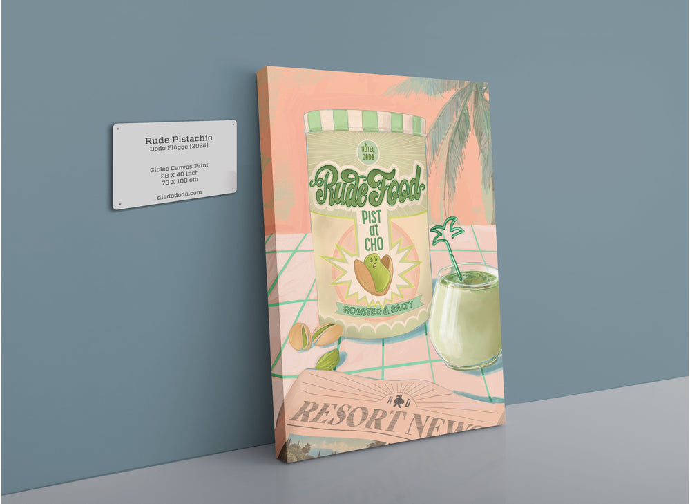 A package of Hôtel Dodo's Rude Pistachio Giclée Canvas Print cut with roasted & salt flavor leaning against a wall next to a framed certificate and above a refreshing green drink on a coaster.