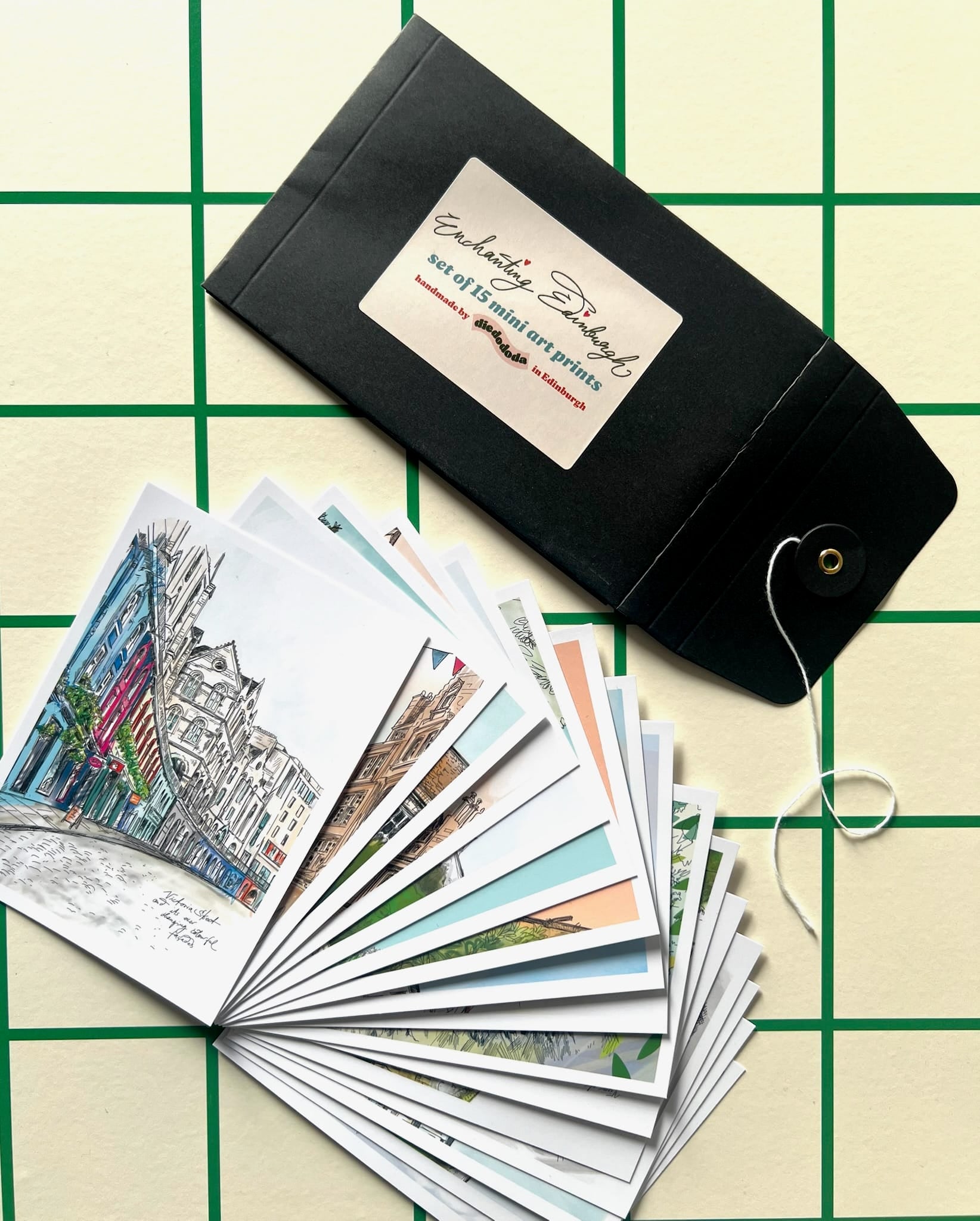 An open black envelope labeled "Edinburgh Mini Print Set | 15 A6 Original Drawings" by Essential Edinburgh displays illustrated art prints—an ideal unique Edinburgh souvenir or thoughtful Scotland gift.