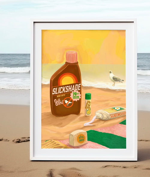 The Screen Queen Giclée Art Print by Hôtel Dodo features sunscreen products and a sea gull on a sandy beach with ocean waves in the background, beautifully framed and propped up on the shore.
