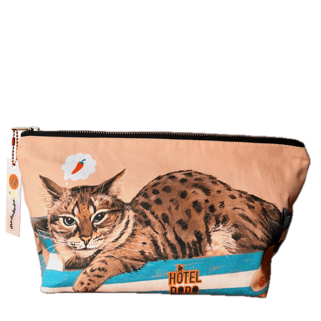 Rectangular cotton zip pouch by Hôtel Dodo, featuring a lounging spotted cat with a fish thought bubble and "Bodega Cat Hot Sauce Pouch" on the front. This washable travel organizer is perfect for your daily essentials.