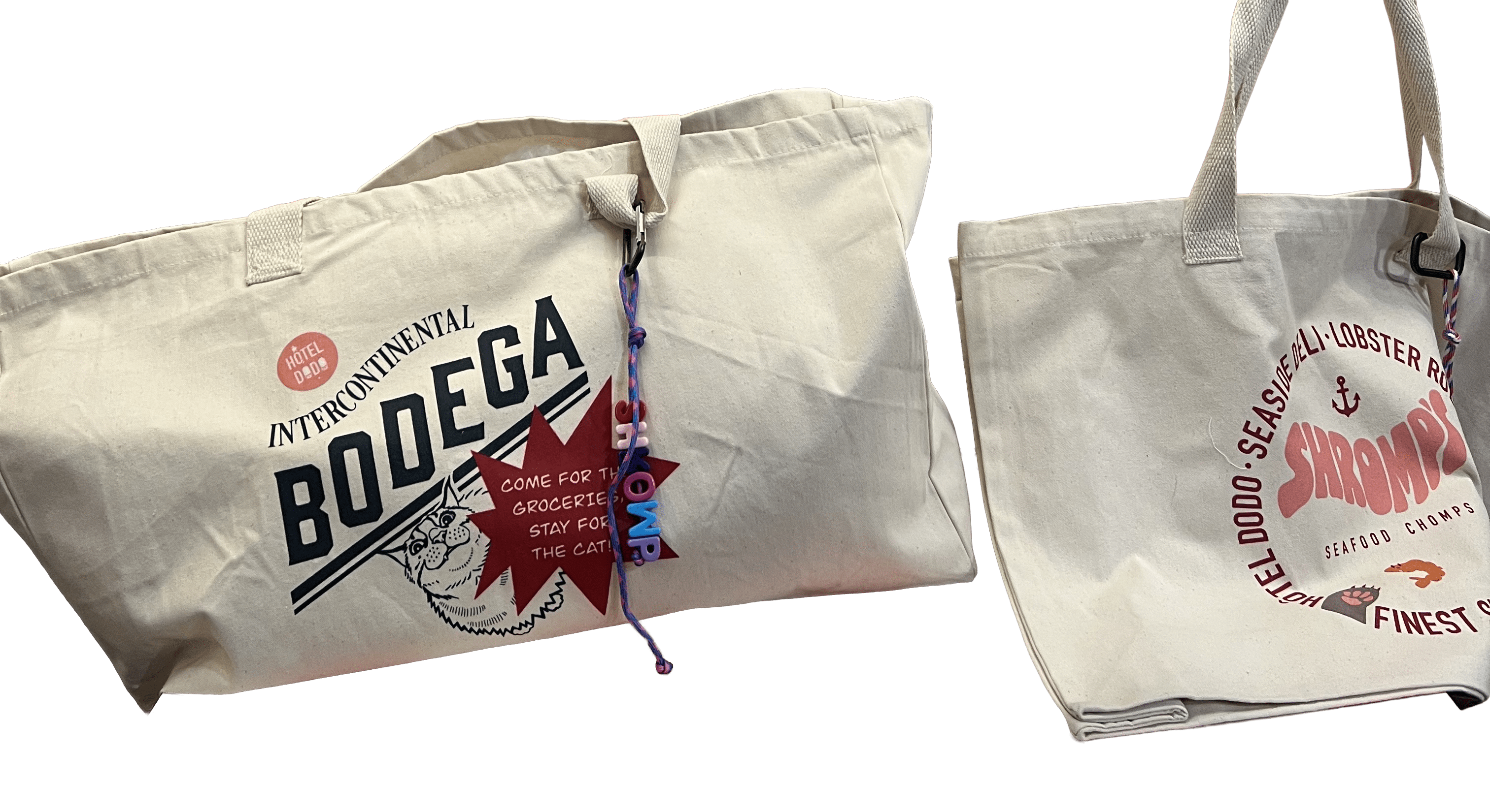 The Bodega/Shromp’s XXL Snack Shopper by Bags by diedododa includes two UK-made, eco-friendly cotton totes: one with a Bodega and cat design, the other seafood-themed with "Shrimp." Both are stylish and sustainable choices.
