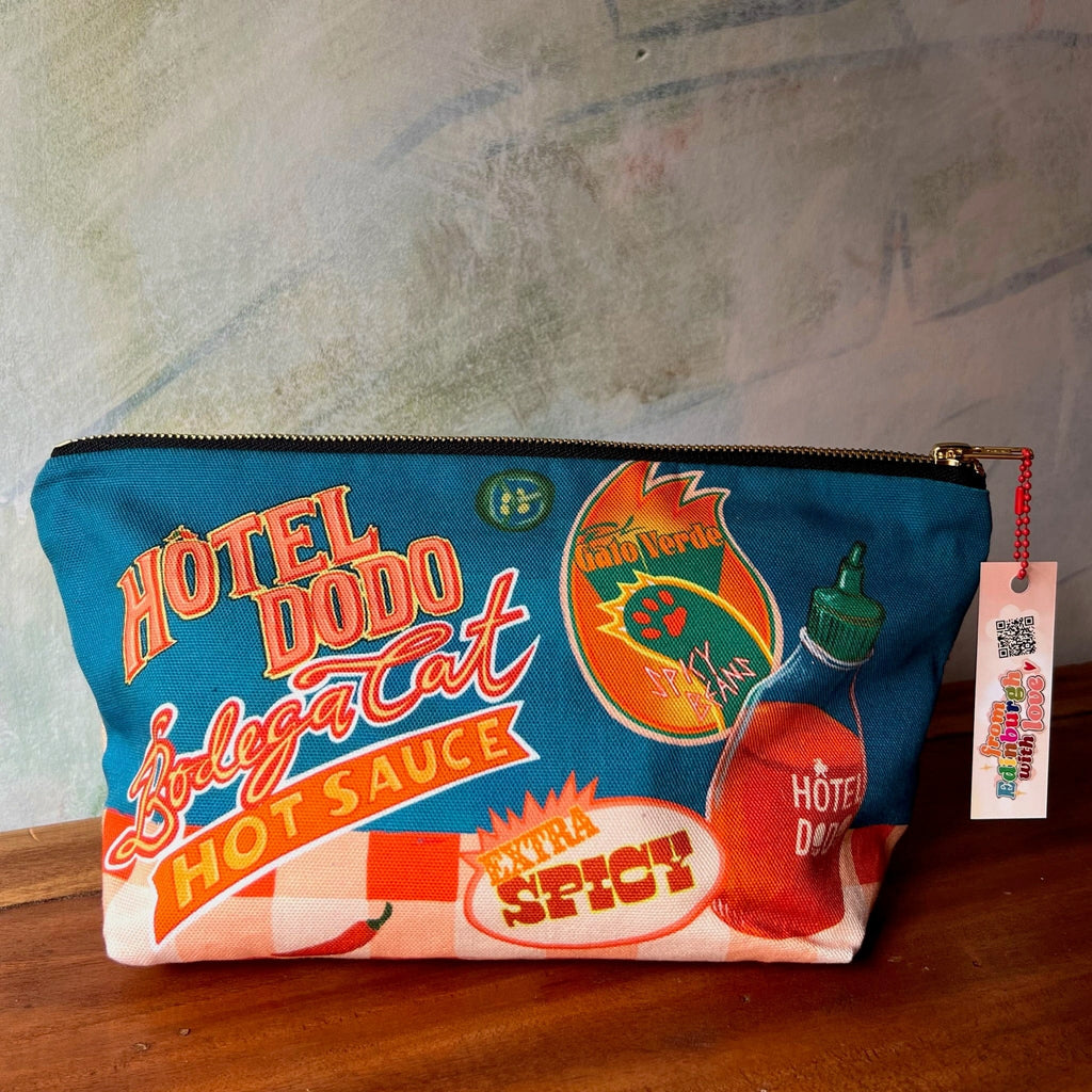 Handmade by Hôtel Dodo, the Bodega Cat Hot Sauce Pouch is a colorful cotton organiser with playful graphics like "HOTEL DODO," "Hot Sauce," and "Bodega Cat"—a quirky, fun pouch for market days.