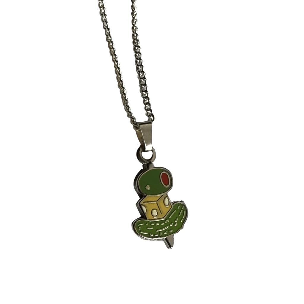 The Canapé Cutie Necklace by Necklaces showcases a whimsical canapé charm shaped like a green and yellow creature with red eyes.