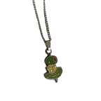 The Canapé Cutie Necklace by Necklaces showcases a whimsical canapé charm shaped like a green and yellow creature with red eyes.