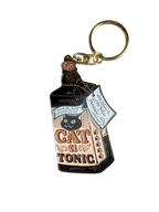 The Catatonic Keyring by Hôtel Dodo is an enamel keyring shaped like a vintage tonic bottle, featuring a black cat and "Cat Tonic" label—ideal as a unique cat-themed keyring or quirky bag charm.