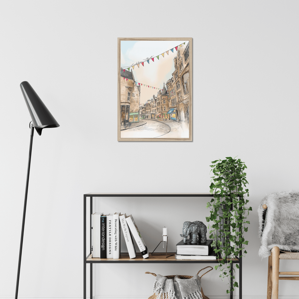 The Cockburn Street Edinburgh Matte Art Print by Essential Edinburgh is displayed in a modern room, hanging above a shelf with books, a plant, and decor. Its illustration captures the charm of the famous street known for its indie shops.