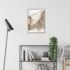 The Cockburn Street Edinburgh Matte Art Print by Essential Edinburgh is displayed in a modern room, hanging above a shelf with books, a plant, and decor. Its illustration captures the charm of the famous street known for its indie shops.