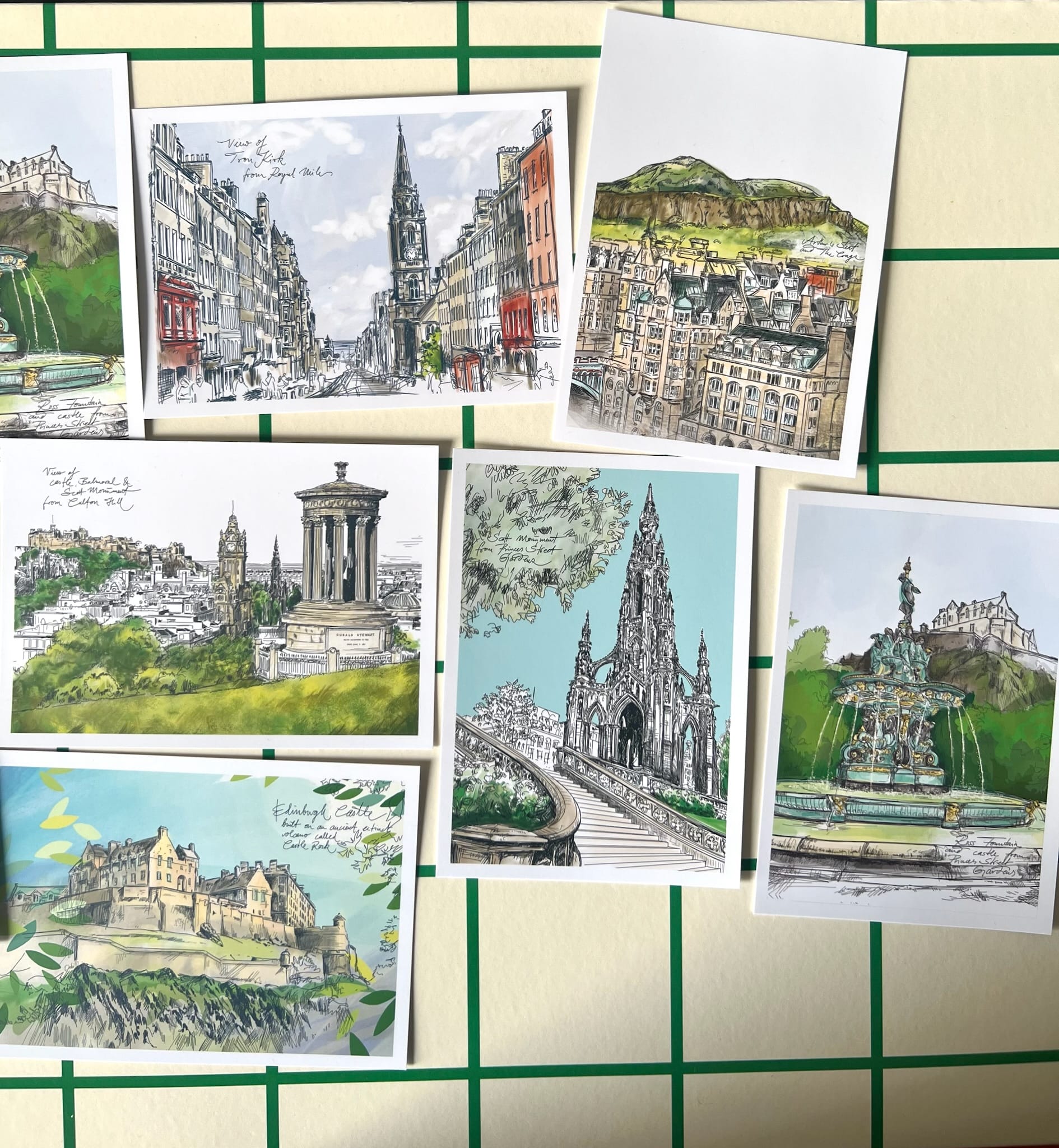 The Edinburgh Mini Print Set by Essential Edinburgh features 15 original A6 drawings of landmarks on a cream and green grid background—perfect as unique art prints or a memorable Scotland gift.