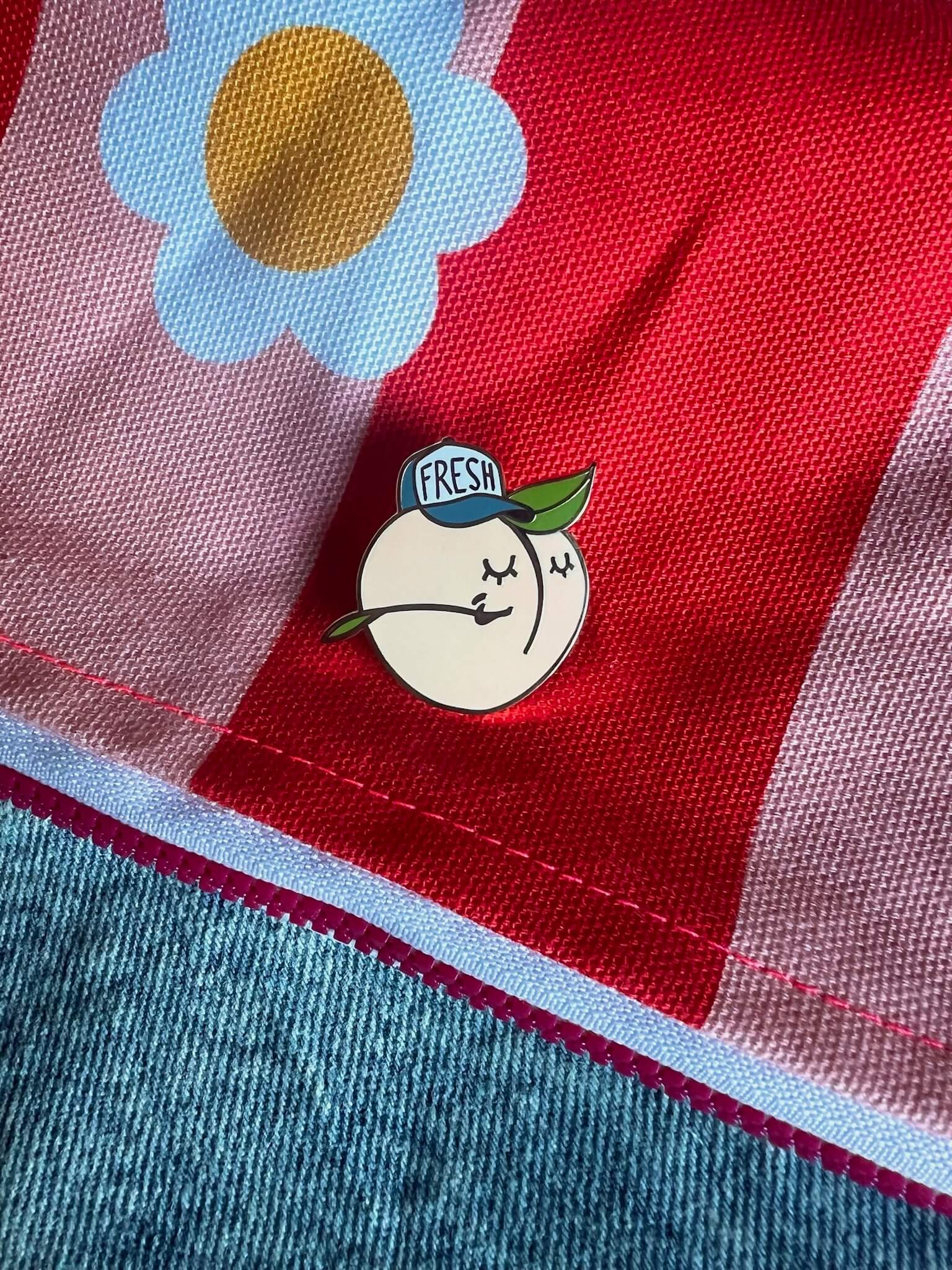 This charming spring accessory, the Farm Fresh Peach Pin by Pins by diedododa, showcases a cartoon peach with a green leaf and 