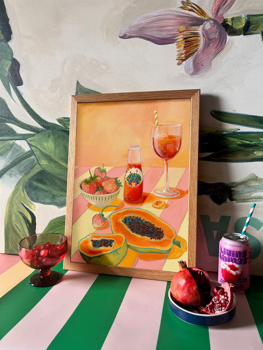 L'Aperitivo Leopardo Giclée Art Print by Hôtel Dodo features fruit, vermouth, and a glass on stripes with fresh fruit and a mural in the background—capturing the charm of an Indian summer picnic.