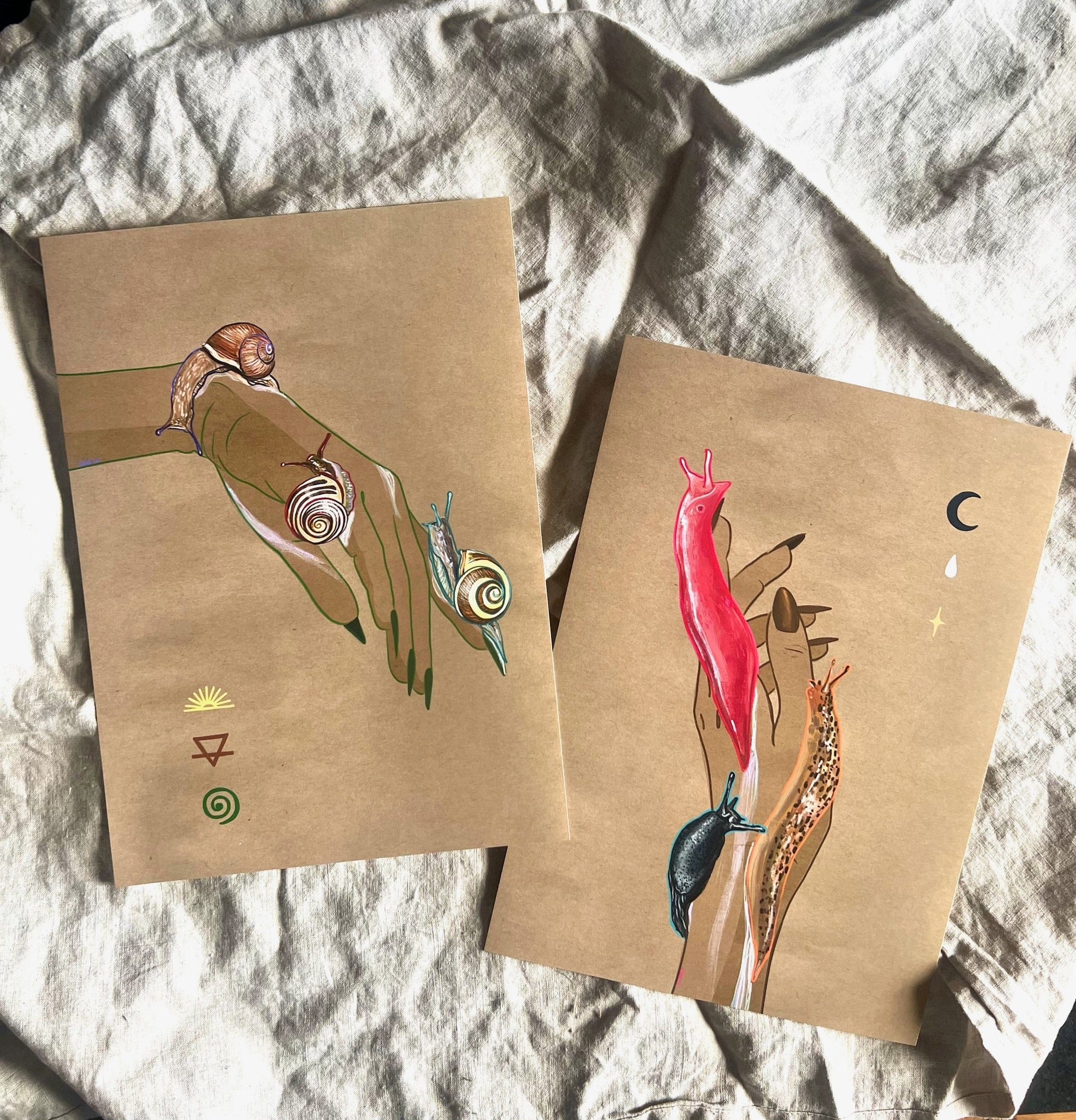 The Midnight Slugs Matte Art Print by Beauty and the Beastie features two drawings on brown paper: a hand with snails and colorful slugs like the Australian pink slug and Black Arion, set against wrinkled white fabric.