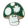 The Irish Luckshroom Pin by Pins by diedododa features a cartoon mushroom with a green cap, white spots, and a neutral-faced stem, all outlined in gold.