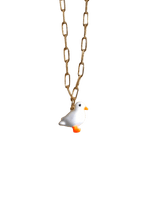 Discover the elegance of our Lucky Ducky Necklace by Necklaces, featuring a charming white bird pendant with an orange beak and feet on a gold small paperclip chain. This exquisite necklace offers an adjustable length for the perfect fit, ensuring both comfort and style.