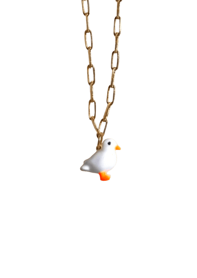 Discover the elegance of our Lucky Ducky Necklace by Necklaces, featuring a charming white bird pendant with an orange beak and feet on a gold small paperclip chain. This exquisite necklace offers an adjustable length for the perfect fit, ensuring both comfort and style.