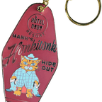 The Hank's Honkitonk Hideout Keyring by Hôtel Dodo features a vintage pink motel key tag design with a cartoon cat in a blue outfit, capturing the charm of an enamel tag reminiscent of a secluded rustic cabin.