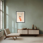 A minimalist living room features a lounge chair, sideboard, ceramic vases, and Kitsch Kanaveral's Smoked Crab Giclée Art Print depicting a Seafood Chomps cocktail with a straw on a pale green wall. Sunlight pours in from large windows.
