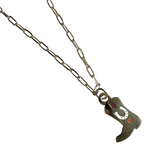 The Tiny Tootin Bootin Necklace by Necklaces is a silver paperclip necklace featuring a cowboy boots pendant, elegantly adorned with a horseshoe and heart design.