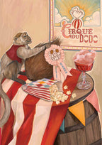 A monkey in a vest sits on a circus table with snacks beside the vibrant “Coconut Shy Cirque Du Dodo” Giclée Art Print by Hôtel Dodo and a first place ribbon.
