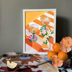 The A L'Orange Giclée Art Print by Hôtel Dodo features two cocktail glasses, white flowers, and an orange on a patterned cloth beside fresh oranges, a lemon wedge, and neroli blossoms—ideal for elevating your table decor.