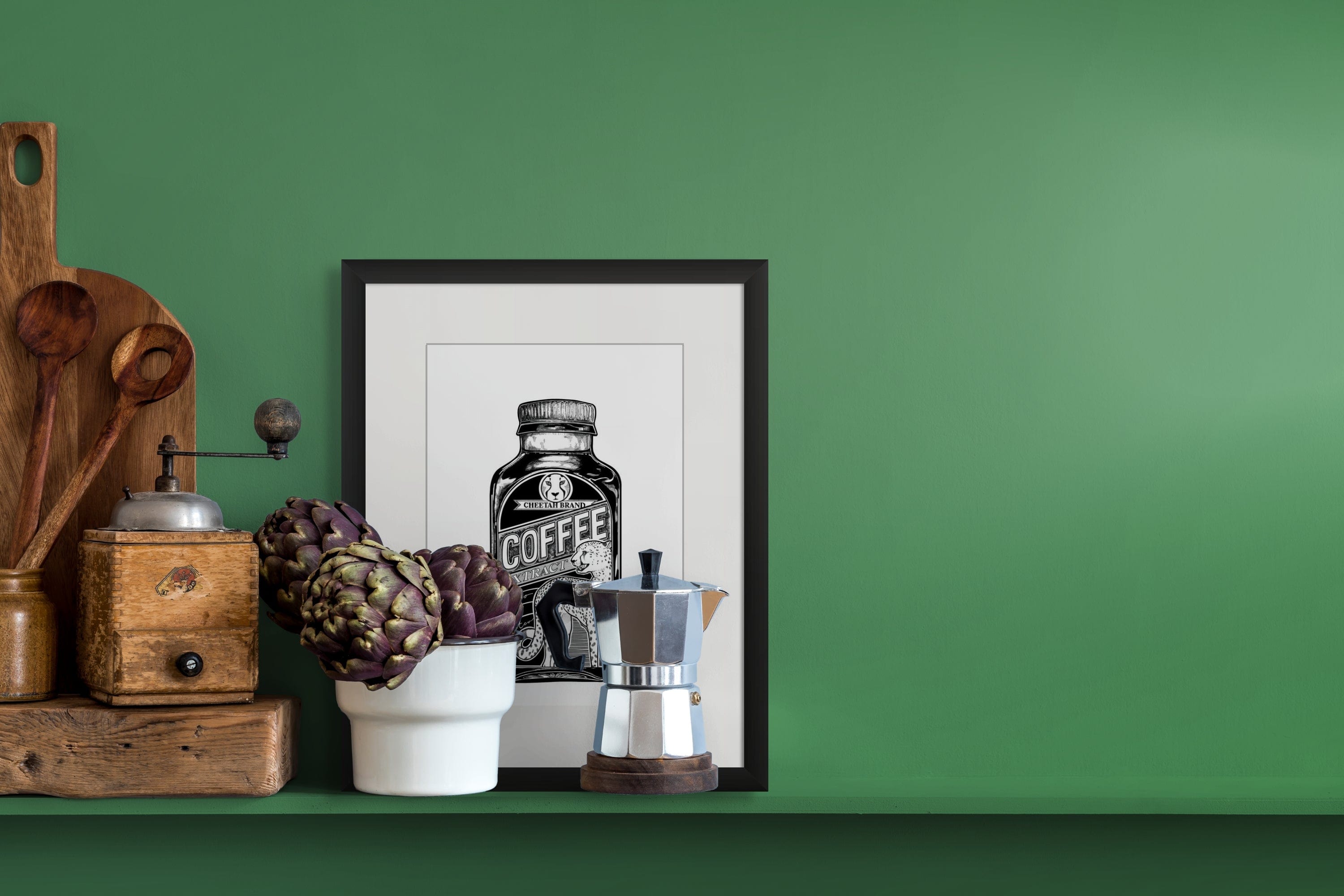 A Potion & Poison Bottles Cheetah Coffee Extract Matte Art Print, artichokes in a white vase, moka pot, wooden utensils, and vintage coffee grinder are displayed on a green shelf against a green wall.