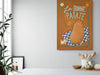 A kitchen with a white counter, plants, and jars of ingredients. A poster on the wall reads "La Bonne Patate" from Aventures Des Créatures, showcasing an illustrated potato on a checkered cloth with the word "j'adore" written on it, celebrating this versatile food.