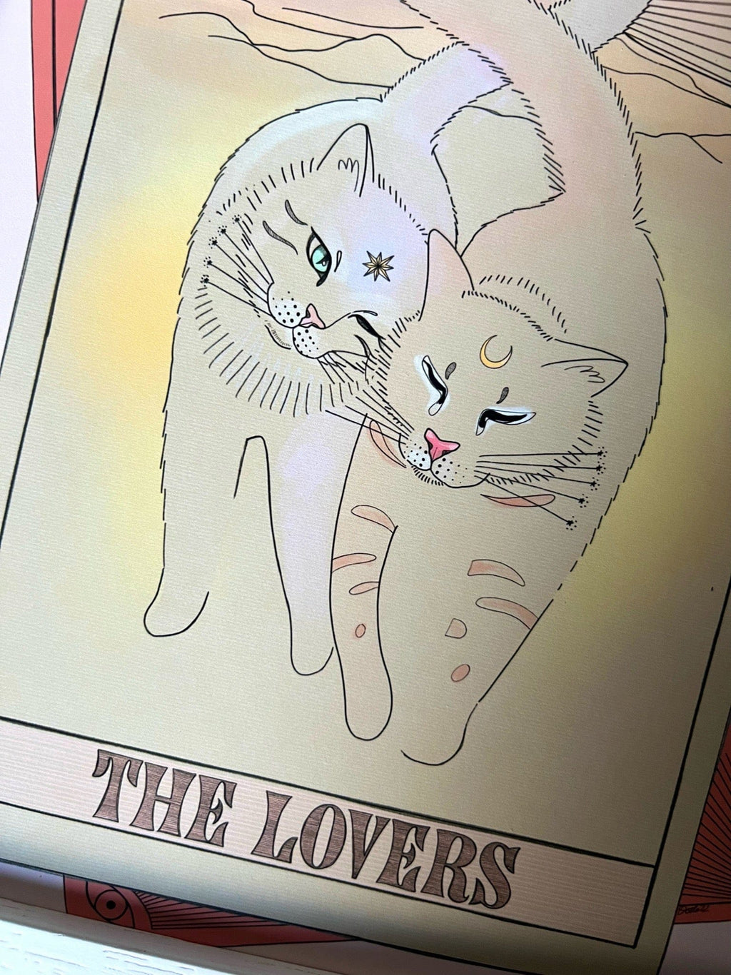 The Lovers Matte Art Print by Tarot Cats features two cats nuzzling—one with a star, one with a crescent moon—above "THE LOVERS," styled like vintage tarot card illustrations.